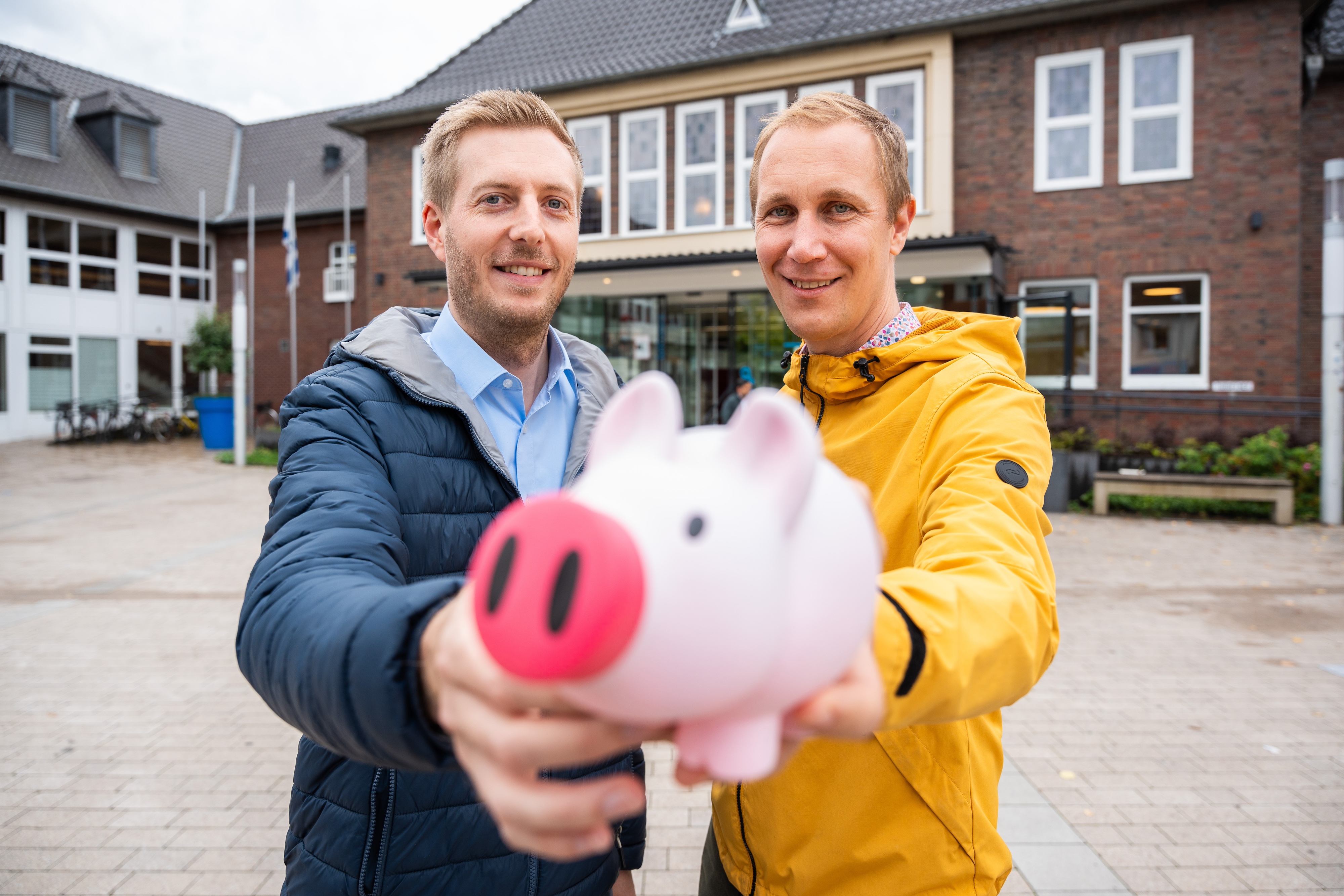 Lucas Risse und Daniel Zimmermann mit einem Sparschwein